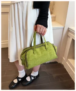 Grüne Wildleder Boston Handtasche Detailansicht, zeigt handgenähte Kanten und Doppelgriffe.