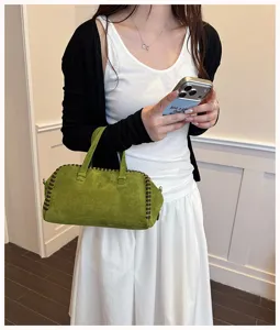 Detailansicht der vintage grünen Wildleder Handtasche mit kontrastierendem Kantennaht-Design.