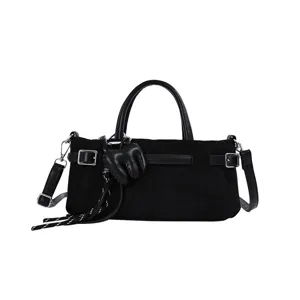 Sac à main noir mat, élégant sac bandoulière avec breloques uniques et boucles stylées.