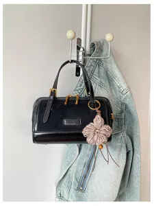 Detail view of a retro color-blocking boston bag with suede and leather texture, featuring chic charm.