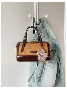 Retro color-blocked Boston handbag with suede and patent leather, stylish shoulder bag for women.