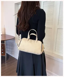 Nahaufnahme der eleganten Retrosuede Boston Handtasche mit dekorativen Seitennaehten und Gurt.
