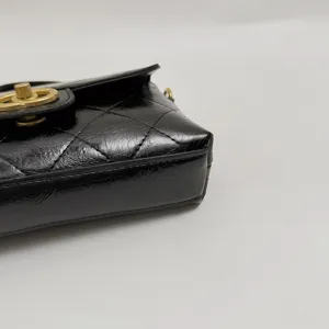 Classic black quilted leather cross body shoulder bag with chic gold turn lock and chain strap.