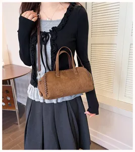 Nahaufnahme der braunen Wildleder Boston Tasche mit handgemachten Kanten und Tragegriffen.