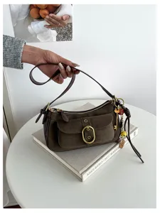 Vintage brown suede shoulder bag with metal buckle and stylish key charm detail for everyday.