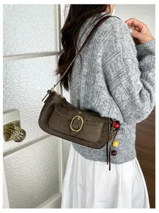 Retro suede shoulder bag detail view featuring metal buckle and chic ball charms for women.
