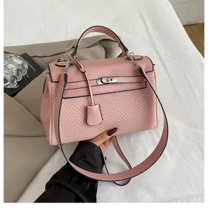 Borsa a mano rosa vista dettaglio con texture in pelle pregiata, chiusura elegante e manico.