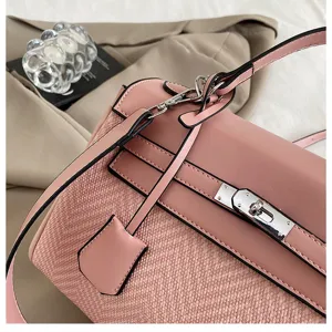 Dettaglio borsa a spalla rosa in pelle testurizzata con chiusura e cinturino fine.