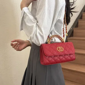 Detailed view of red quilted shoulder bag with chic chain strap and gold clasp design.