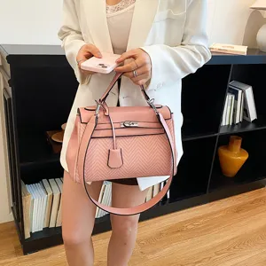 Vista dettagliata di borsa a mano rosa chic con trama tessuta unica e chiusura metallica.