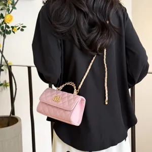Detail view of a chic pink quilted shoulder bag featuring gold chain strap and elegant top handle.