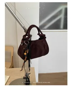 Detail shot of retro brown suede pleated dumpling handbag showcasing unique texture and chic design.
