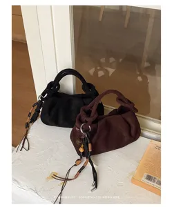 Retro suede dumpling handbag featuring knotted handles and chic beaded tassel charms.