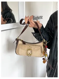 Detailed view of vintage suede shoulder bag featuring contrast leather trim and chic metal hardware.