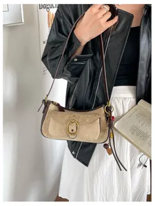 Vintage suede shoulder bag detail, contrast color design with metal buckle and strap.
