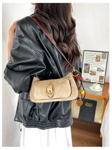 Retro suede shoulder bag detail showing metal buckle flap, patchwork design and cute heart charm.
