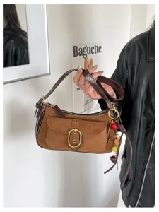Vintage suede shoulder bag for women, chic baguette handbag with buckle and strap.