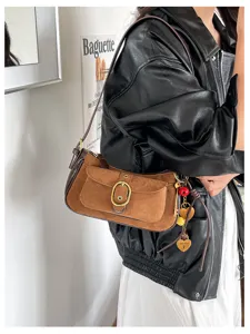 Vintage brown suede shoulder bag with metal buckle and chic charms for women daily wear.