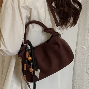 Retro brown suede shoulder bag for women, trendy dumpling hobo bag with cute charms and knot.