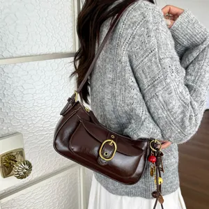 Retro brown women shoulder bag casual underarm bag with metal buckle and charms.