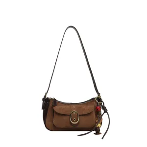 Retro brown suede shoulder bag with metal buckle and chic front pocket for women.