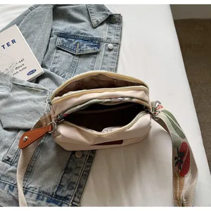 Casual canvas crossbody tas met breed bedrukt hengsel en handig dubbel ritsvak.