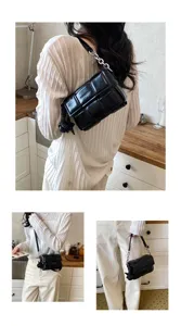 Vue détaillée du sac bandoulière noir tissé pour femme avec grille en cuir et chaîne.