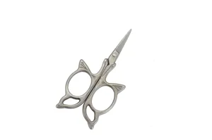 Close-up view of vintage craft metal scissors featuring ornate cat ear handles for sewing.