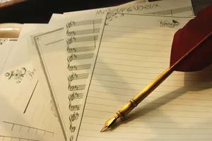 Ensemble de papier à lettres vintage avec plume d'oie, notes de musique et motifs marins.