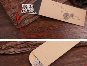 Gros plan sur le marque-page en métal ajouré avec pompon rouge et étui en kraft