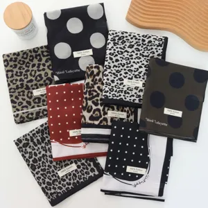Detail view of assorted polka dot and leopard print cotton scarves arranged neatly.