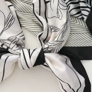 Detalle de pañuelo de seda en blanco y negro, diseño de arte geométrico elegante, accesorio.