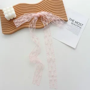 Detailed close-up of pink lace ribbon choker with delicate star embroidery design.