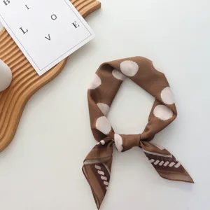 Détail de foulard en soie à pois marron, tissu doux et design de motif élégant.