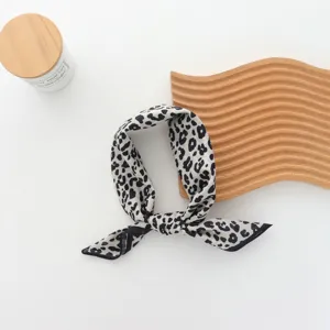 Close-up detail of a chic black and white patterned scarf, elegantly tied for styling accessories.