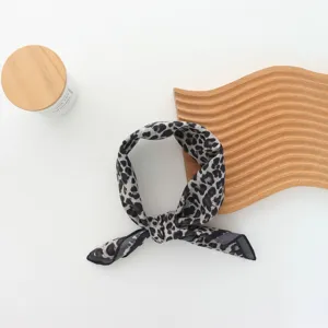 Leopard print hair scarf detail showing soft fabric texture and elegant knotted design.