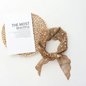 Brown floral lace triangle headscarf detail showing delicate embroidery and mesh fabric.