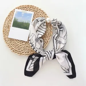 Elegante pañuelo de cuello en seda con estampado blanco y negro y cierre magnético.