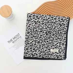 Detailed view of a stylish cotton leopard print scarf with fine stitching and soft fabric.