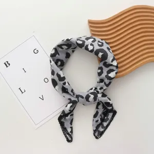 Grijze sjaal met luipaardprint en kantrand, ideaal als nek- of tassenaccessoire.