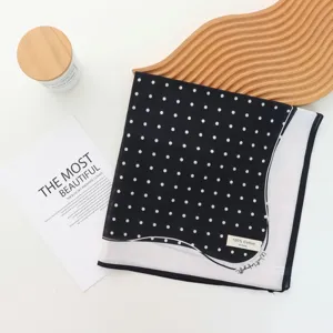Detailed view of the chic black and white polka dot cotton scarf with elegant retro style.