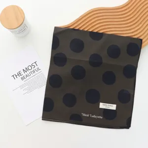 Detailed view of the retro black polka dot pure cotton scarf, showing soft fabric texture and tags.