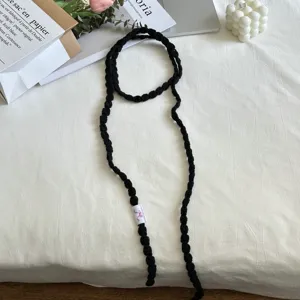 Detailed view of handmade black crochet ribbon choker scarf, soft knitted texture, sweet cool style.