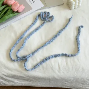 Nahaufnahme eines handgemachten blauen Häkel-Schals mit Blütendetail, Accessoire.