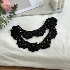 Close-up of black handmade crochet fake collar with delicate texture and pearl detail.