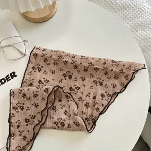Primo piano dettagliato del fazzoletto triangolare floreale giapponese con bordi ondulati.