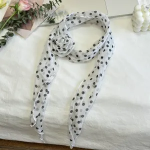 Detailweergave van de witte stippensjaal met een elegant 3D stoffen bloemaccent.