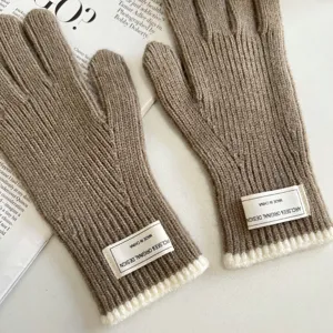 Detailed close-up view of cozy brown knit gloves with ribbed white cuffs and woven label design.