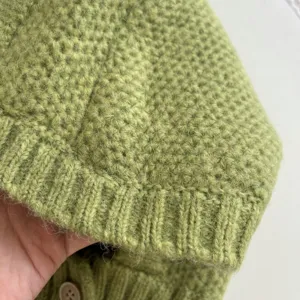 Nahaufnahme zeigt die weiche Stricktextur und den Rippsaum der kuscheligen grünen Sturmhaube.