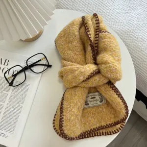 Knit scarf detail showing yellow textured yarn and brown stitched edges for autumn and winter.